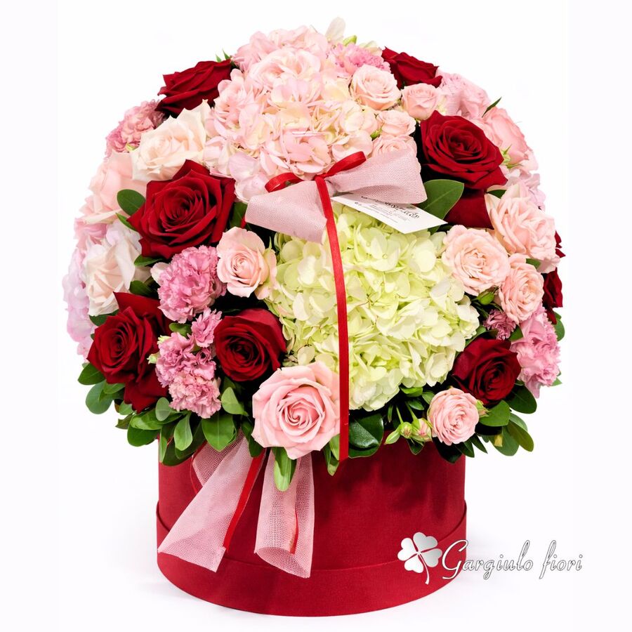 Composizione in box rosso con rose rosse, rosa e ortensie bianche